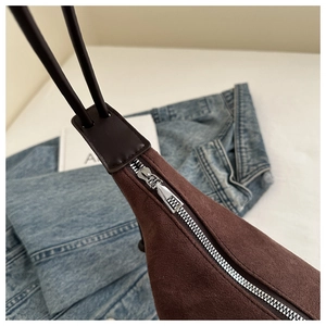 Close-up of silver zipper and premium dark brown suede texture on this tote bag