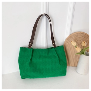 Dettaglio della borsa tote trapuntata in velluto verde con tracolla in pelle marrone