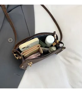 Top view of brown leather crossbody bag showing spacious interior with daily essentials