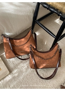 Gros plan du sac cabas en daim fauve avec bordure en cuir et détail de chaîne en argent