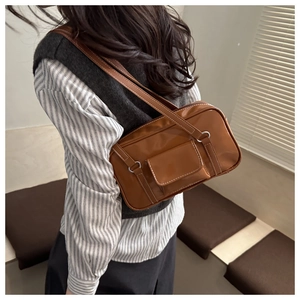 Close-up of brown PU leather shoulder bag with white contrast stitching details
