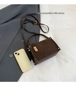 Detailed size comparison of dark brown suede square bag with phone and metal buckle