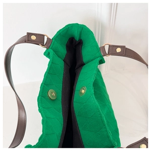 Dettaglio borsa shopper trapuntata verde con chiusura magnetica e manici in pelle