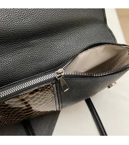 Makro-Detail der Schlangenleder-Tasche mit Silber-Reißverschluss und Fischgräten-Futter