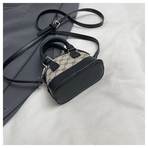 Detail of mini vintage print shoulder bag with black leather trim and crossbody strap