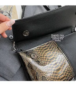 Details zum Magnetverschluss der schwarzen Handtasche aus Leder mit Kroko-Prägung