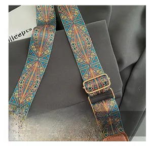 Close-up of ethnic style woven crossbody bag strap with vintage bronze metal buckle