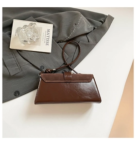 Detailed view of a brown vintage baguette bag with suede texture and knotted strap