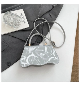 Detail of silver handbag with wave base, letter print and golden hardware on fabric