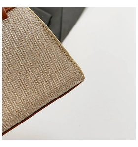 Macro shot of champagne sequin woven texture and smooth brown leather edge on a handbag
