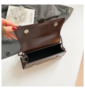 Detailed view of the dark brown glossy PU leather handbag showing dual magnetic closure