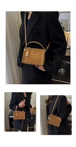 Detail showing vintage brown matte leather box bag with gold lock and sturdy handle