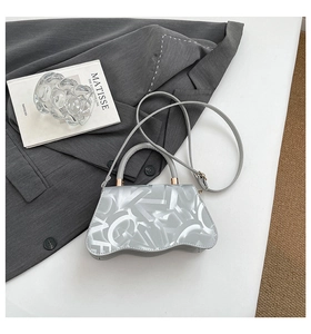 Detail of silver metallic handbag with geometric texture and unique wavy bottom base