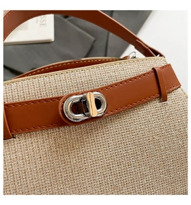 Macro shot of shimmering gold fabric texture with silver twist lock and brown leather trim