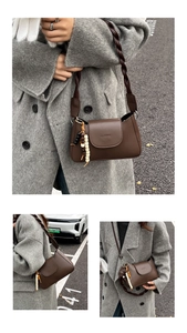 Detail of dark brown leather underarm bag with a twisted shoulder strap and beaded tassel