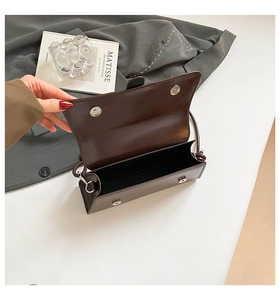Detail view of the brown leather crossbody bag showing magnetic closure and interior space
