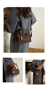 Brown leather crossbody bag detail with golden lock and strap on a wool coat