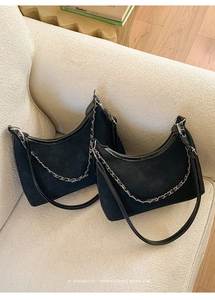 Détail du sac bandoulière en daim noir avec chaîne argentée et texte Fashion chic