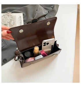 Detail view of the spacious interior of a dark coffee baguette bag with magnetic buckle