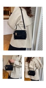 Detailed look at the black suede crossbody bag with gold metal clasp on a beige trench coat