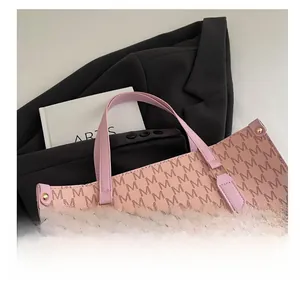 Macro detail of pink monogram tote bag featuring embossed logo and golden metal rivets