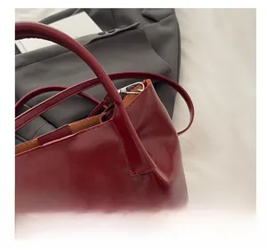 Close-up of the wine red bucket bag showing polished leather texture and inner lining