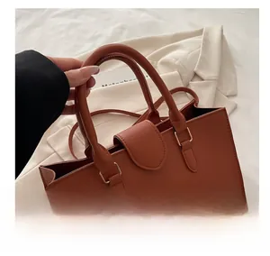 Dettaglio della borsa tote in pelle caramello con trama a grana e manici arrotondati