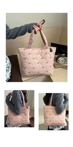 Dettaglio della borsa tote rosa trapuntata con ricamo a fiocco e pendente logo