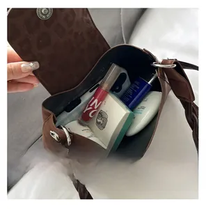 Internal view of the brown suede saddle bag showing its capacity for daily cosmetics