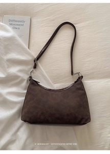 Gros plan du sac hobo marron foncé vintage avec texture mate et détails argentés