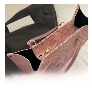 Detail of a smooth golden metal zipper on a pink tote bag with letter patterns