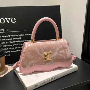 Pink monogram handbag with wavy base and gold logo on white books in minimalist setting