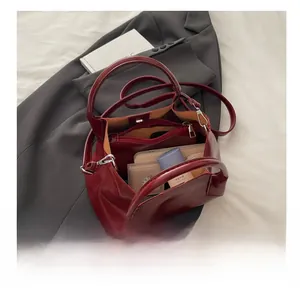 Detail of burgundy tote bag interior showing spacious capacity with makeup essentials