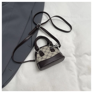 Close-up of vintage mini shell bag with monogram canvas and brown leather handle details