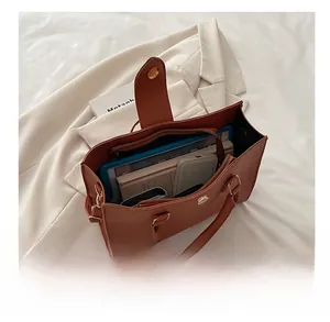 Interno della borsa in pelle marrone che mostra la grande capacità per tablet e cellulare