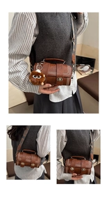 Detail of retro brown Boston bag with metal twist lock, rivets, and woven strap
