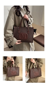 Detail of brown tote bag featuring all-over M-letter print and large embossed logo