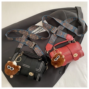 Detail of retro leather bags with rivet trim, ethnic strap and plush bear charm