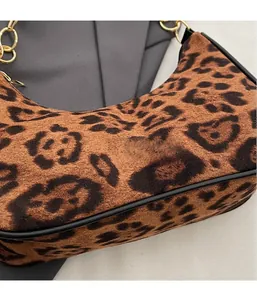 Detail of leopard print crescent bag featuring soft velvet texture and gold metal chain