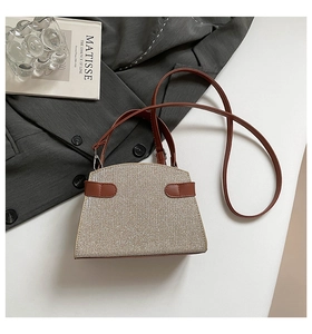 Detail of vintage square handbag with metallic texture, leather handle and shoulder strap
