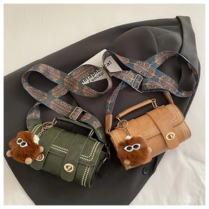 Close-up of matte PU leather texture with gold rivets and vintage ethnic canvas straps