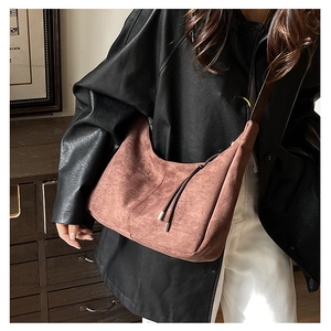 Detail of vintage brown suede crescent bag featuring retro fringe and high-quality zipper