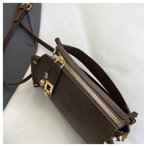 Close-up of brown lychee texture leather with gold buckle and hardware on square bag