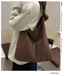 Detail of large leopard print tote bag in dark brown suede with stylish embossed patterns