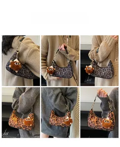 Detail view of leopard print crescent shoulder bag with gold chain strap and plush charm