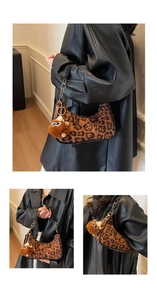 Detail view of leopard hobo bag with furry charm and metallic chain strap detail