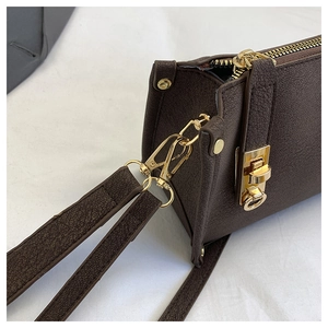Detailed macro view of dark brown litchi pattern leather and luxury gold metal twist lock