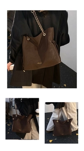 Close-up of a large brown tote bag with gold chain strap and embossed logo detail