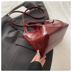 Détail du sac cabas rouge foncé en cuir PU montrant sa texture lisse et ses poignées