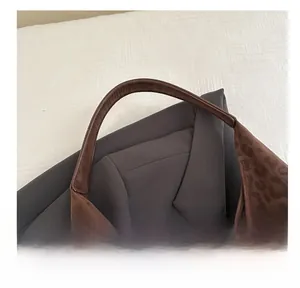 Detailed view of the brown leopard print tote bag with premium leather handle and stitching